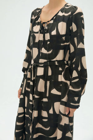 Close-up of inkbrush geo abstract midi dress showing tie-front waist detail and airy drape