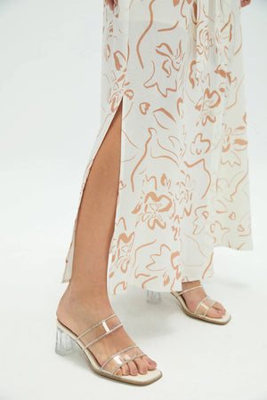 Detail view of sand bloom belted shirt dress showing skirt slit and draped fabric