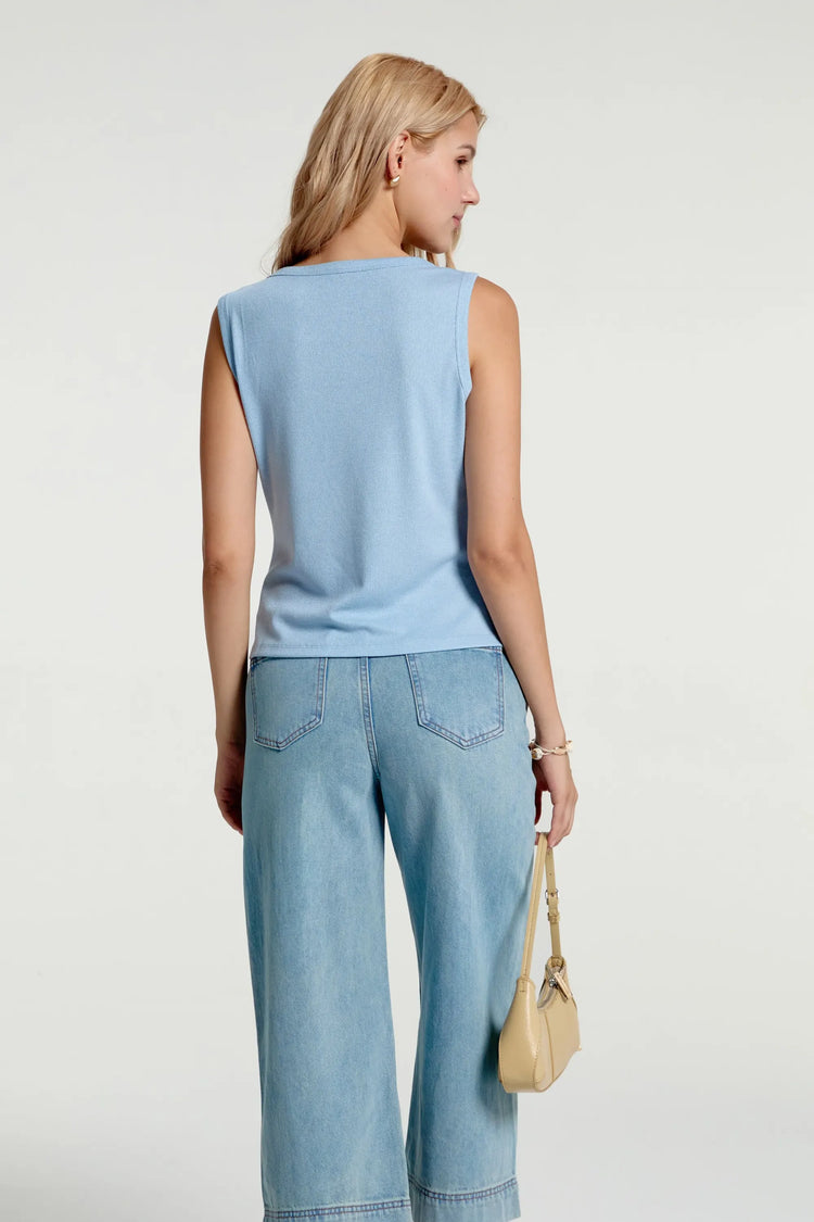 Back view of women’s coastal blue charm-embellished knit tank styled with blue jeans