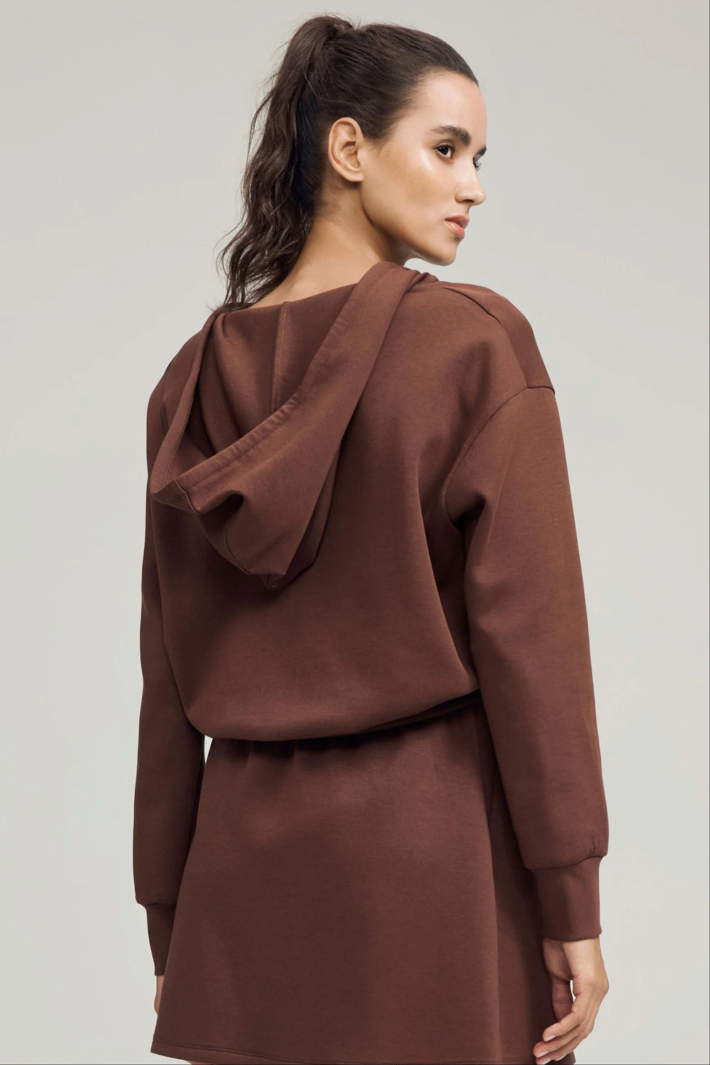 Cropped half-zip fleece hoodie in chestnut brown styled with a matching skirt, front view