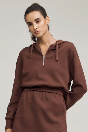Cropped half-zip fleece hoodie in chestnut brown styled with a matching skirt, front view