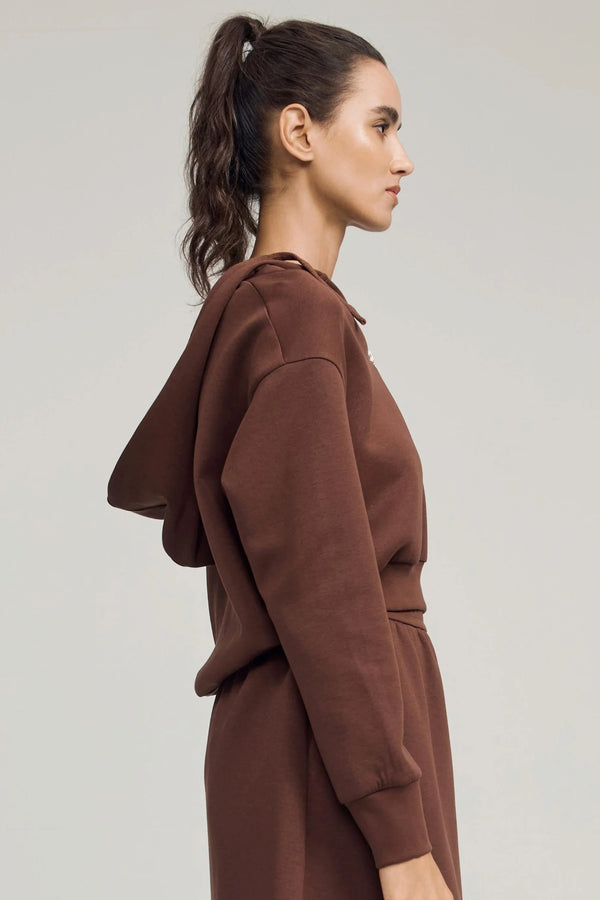 Side view of a chestnut brown cropped half-zip hoodie with a relaxed, easy drape
