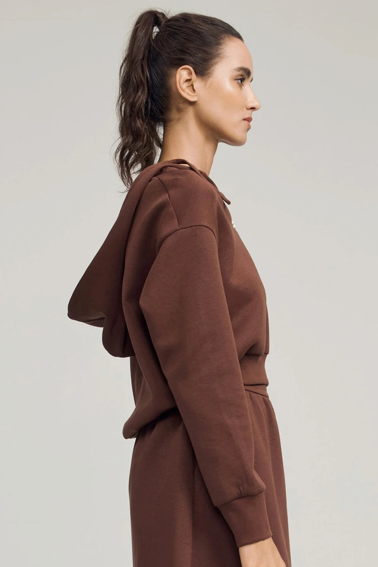 Side view of a chestnut brown cropped half-zip hoodie with a relaxed, easy drape
