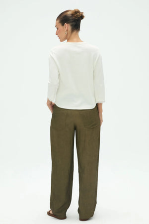 Back view of women’s everyday V-neck top styled with olive green pants
