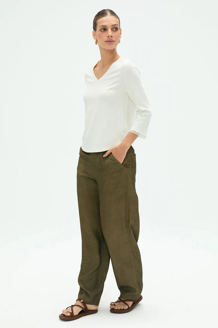 Side view of women’s V-neck top styled with olive green pants, showing relaxed drape