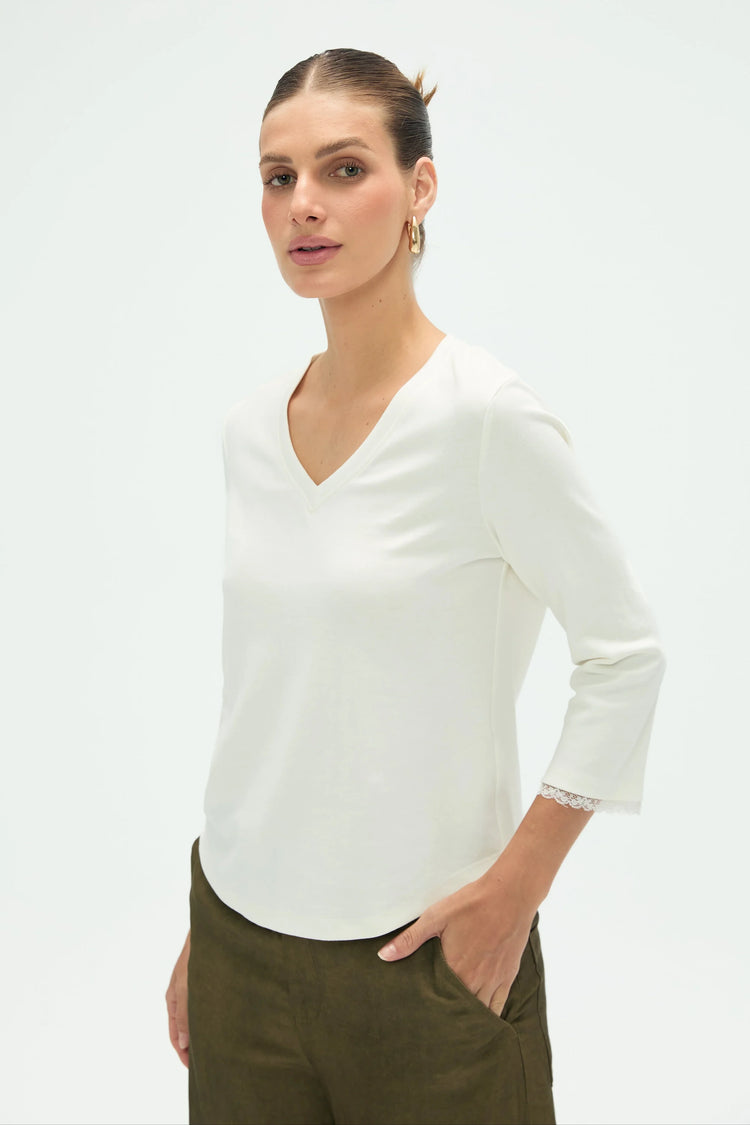 Women’s everyday V-neck top styled with olive green pants, upper-body front view