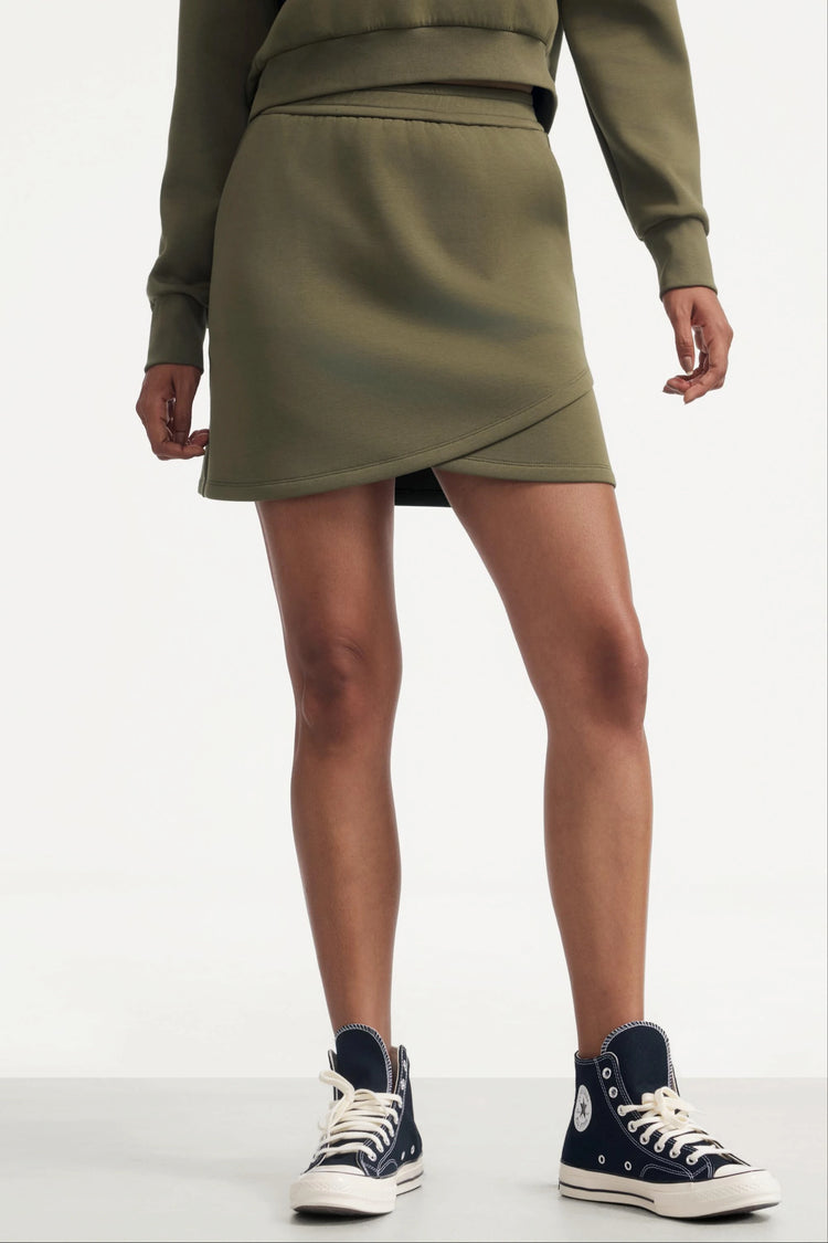 Front view of the Emara wrap-front fleece skirt in soft moss, featuring a clean silhouette and relaxed everyday fit.