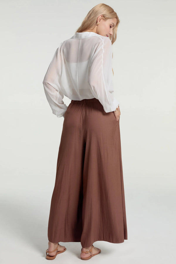 Flowy palazzo pants styled with a white shirt, back view for a polished work-ready look