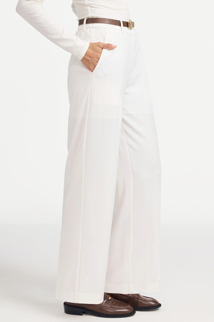 Side view of flow tailored trousers highlighting a fluid drape and high-rise silhouette
