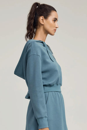 Side view of women’s slate blue half-zip hoodie showing soft structure and easy fit