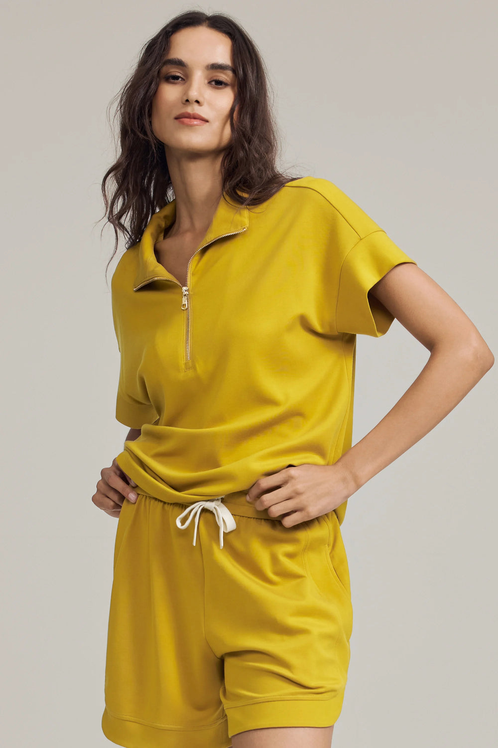 Half-zip lounge polo in marigold yellow styled with matching shorts, front view