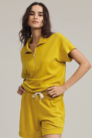 Half-zip lounge polo in marigold yellow styled with matching shorts, front view