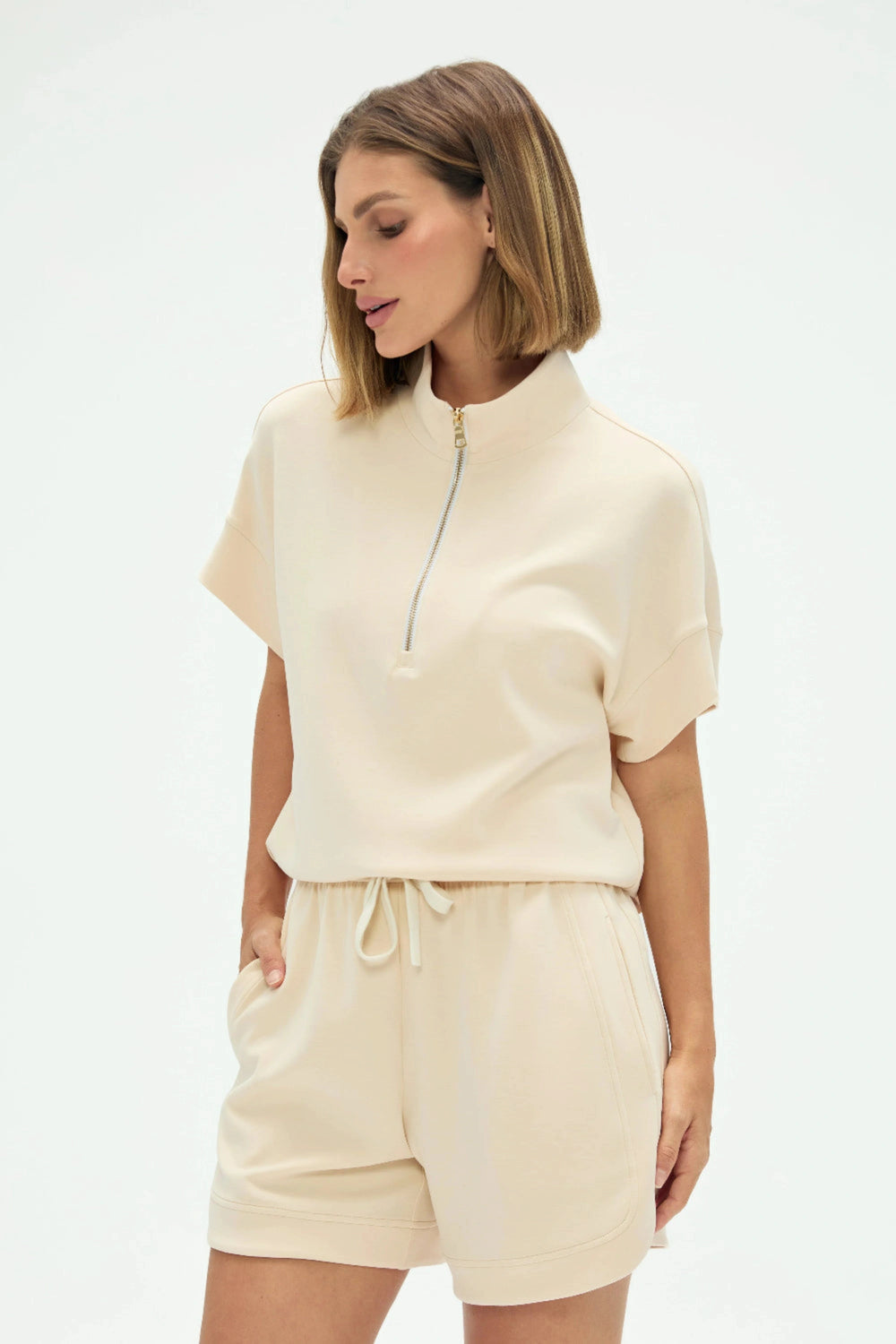 Half-zip lounge polo in soft oatmilk styled with matching shorts, front view