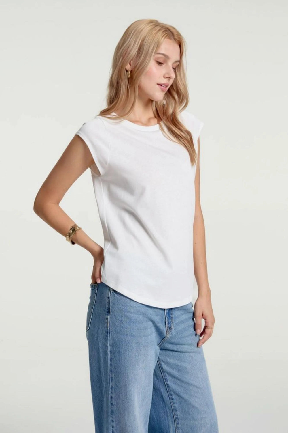 Back view of women’s porcelain white lace-back cap sleeve tee styled with blue jeans