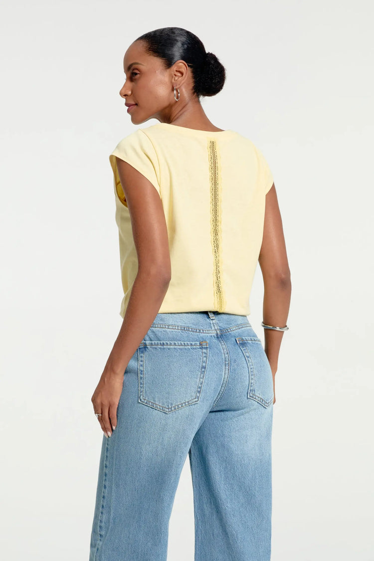 Back view of women’s soft lemon lace-back cap sleeve tee styled with blue jeans