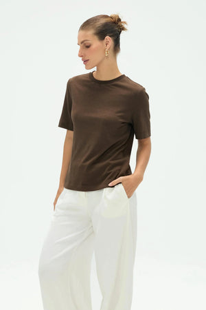 Women’s espresso linen Supima cotton crewneck tee styled with white pants, upper-body front view