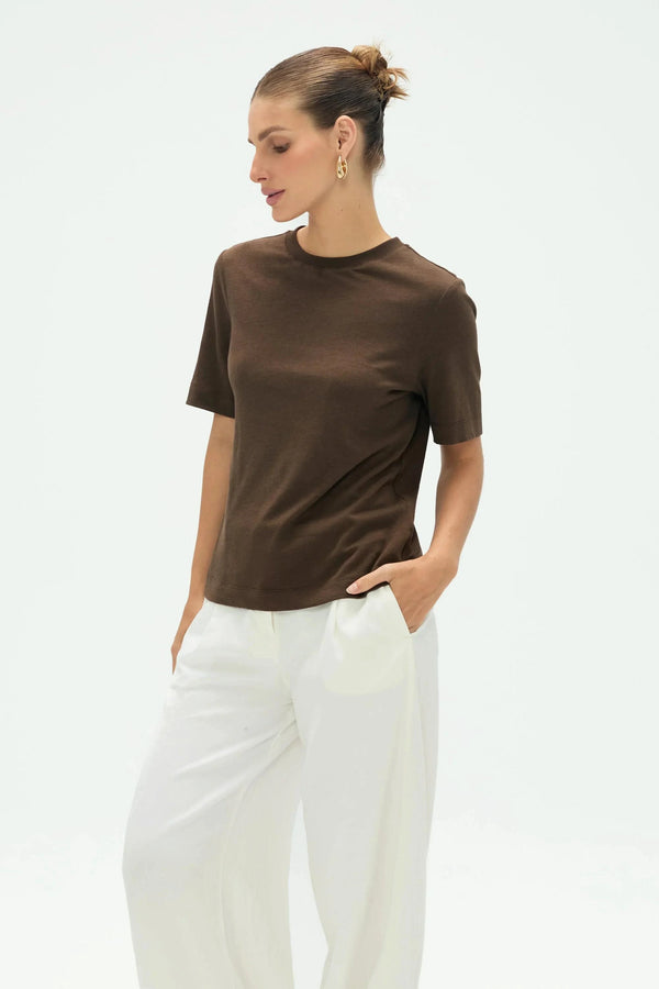 Women’s espresso linen Supima cotton crewneck tee styled with white pants, upper-body front view