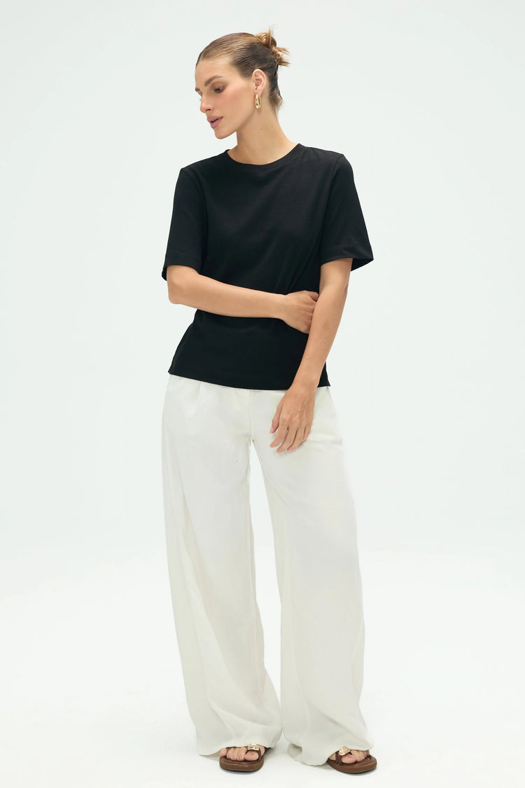 Women’s noir black linen Supima cotton tee styled with white pants for a clean full-body look