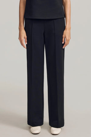 Front view of luxe flare pants in black featuring a high-rise, wide-leg silhouette