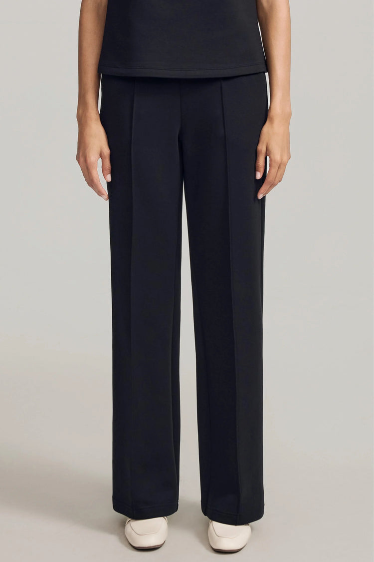 Front view of luxe flare pants in black featuring a high-rise, wide-leg silhouette