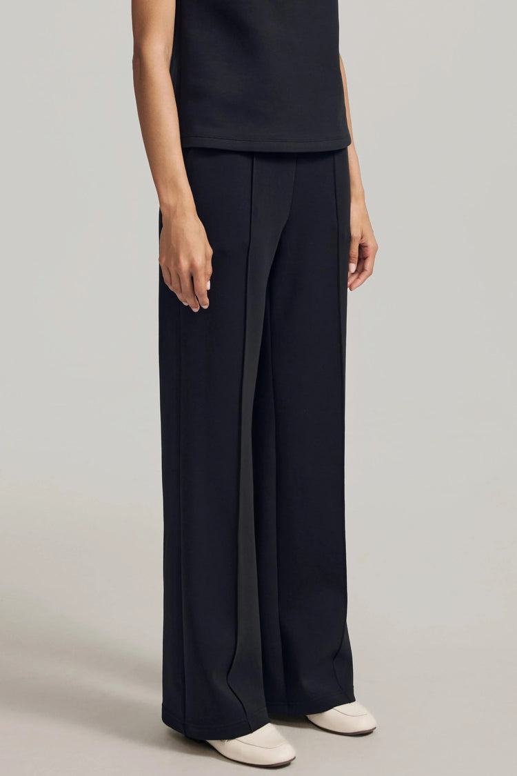 Side view of black wool-blend flare pants with a clean, fluid drape
