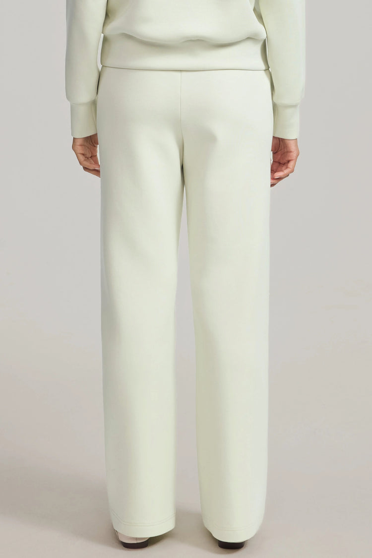 Back view of pistachio cream high-rise flare pants with a clean, refined fit