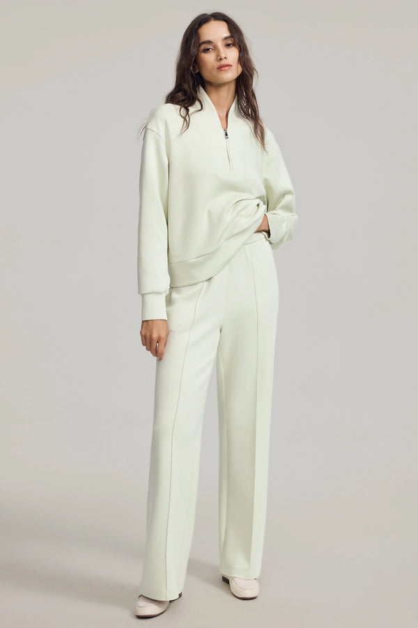Pistachio cream luxe flare pants styled with a matching sweatshirt, front view on grey background