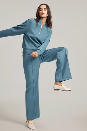Side view of Slate Blue wool-blend flare pants styled with a matching sweatshirt