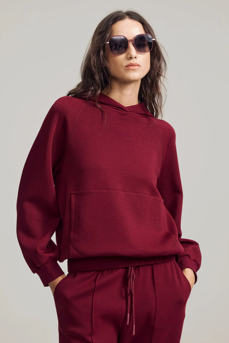Women’s burgundy wine hoodie styled with sunglasses for an elevated casual look