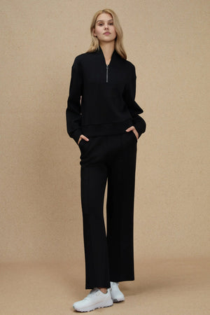 Luxe wool-blend half-zip pullover in black styled with matching trousers, front view on warm neutral background