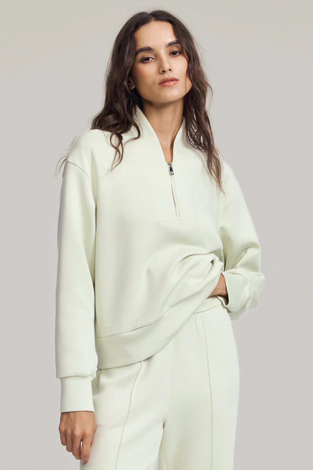 Luxe half-zip pullover in Pistachio Cream styled with matching trousers, front view on grey background