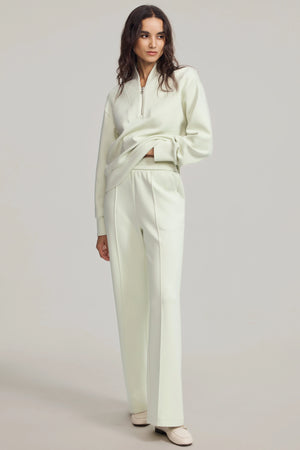 Front view of a Pistachio Cream half-zip pullover highlighting relaxed fit and soft drape