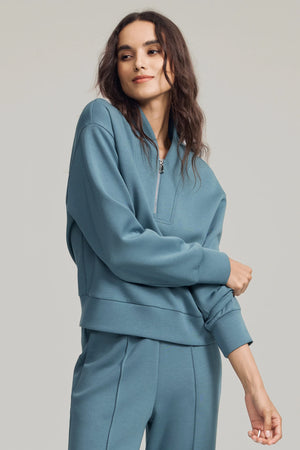 Luxe half-zip pullover in Slate Blue styled with matching trousers, front view on grey background