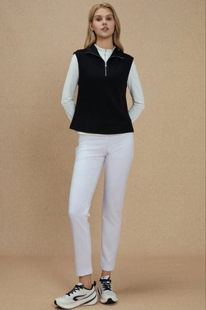 Jet Black sleeveless half-zip pullover layered over a white long-sleeve top for a modern performance look