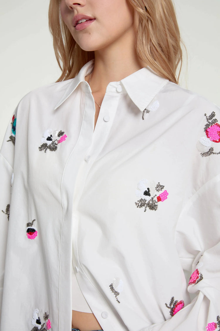 Close-up of the embroidered collar detail on an oversized button-down shirt