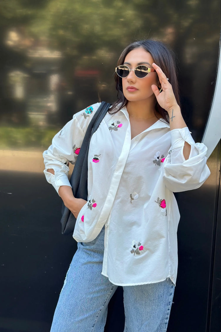 Side view of an oversized embroidered shirt with relaxed structure, styled for everyday wear