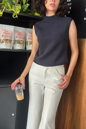 Inkstone Blue sleeveless sculpted top worn for everyday movement, shown in a relaxed café setting