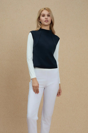 Sculpted sleeveless top in Inkstone Blue layered over a white long-sleeve, front view on warm neutral background