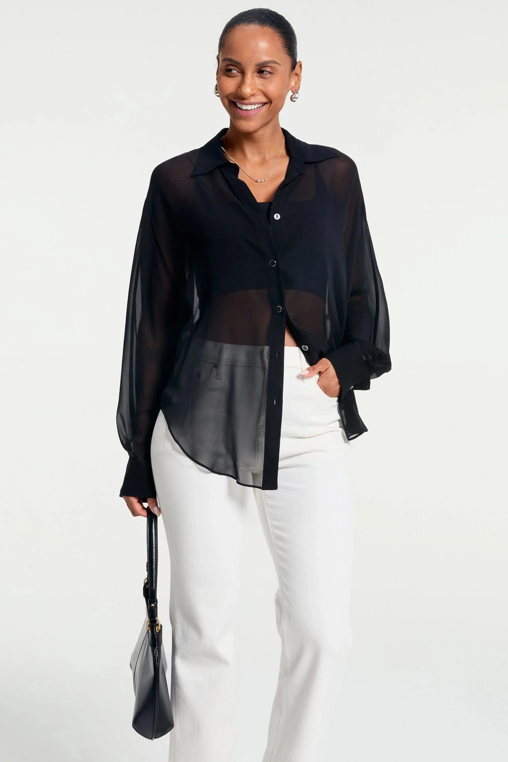 Sheer black silk oversized button-down shirt styled with white trousers, front view