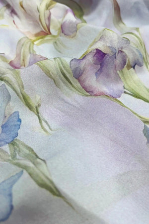 Close-up of sheer silk chiffon fabric with soft lavender floral print and airy texture
