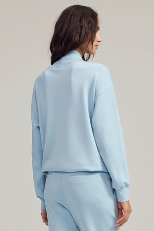 Back view of a soft drape funnel-neck pullover with a clean, relaxed silhouette