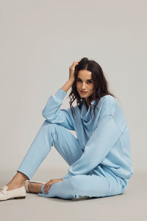 Tencel™ funnel-neck pullover in Powder Blue worn in a seated pose, emphasizing relaxed comfort