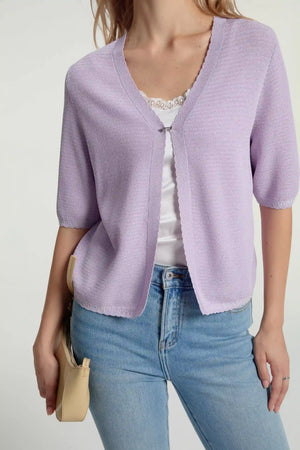 Close-up of soft knit hook-front cardigan fabric showing airy texture and fine knit detail