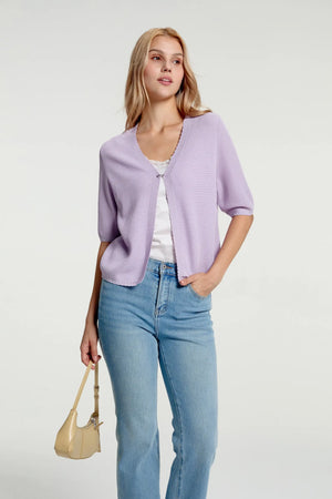 Women’s soft knit hook-front cardigan styled with blue jeans and a handbag, half-body front view

