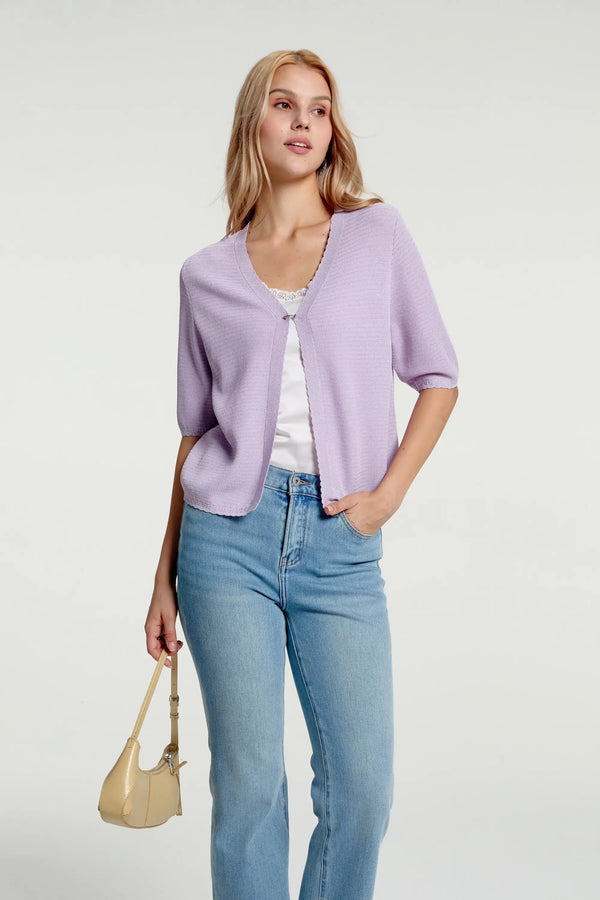 Women’s soft knit hook-front cardigan styled with blue jeans and a handbag, half-body front view
