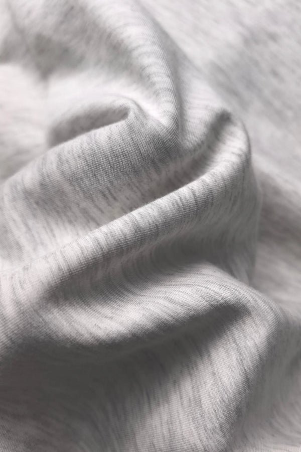 Close-up of breathable Tencel™ fabric showing a silky-smooth texture and soft stretch