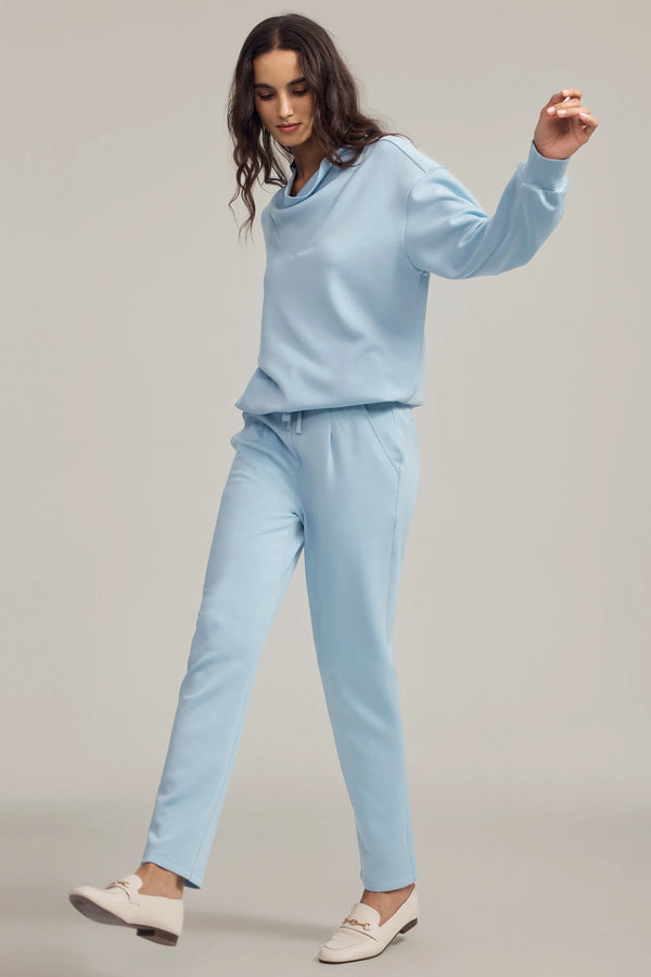 Soft tapered lounge pants in powder blue styled with a matching pullover, front view