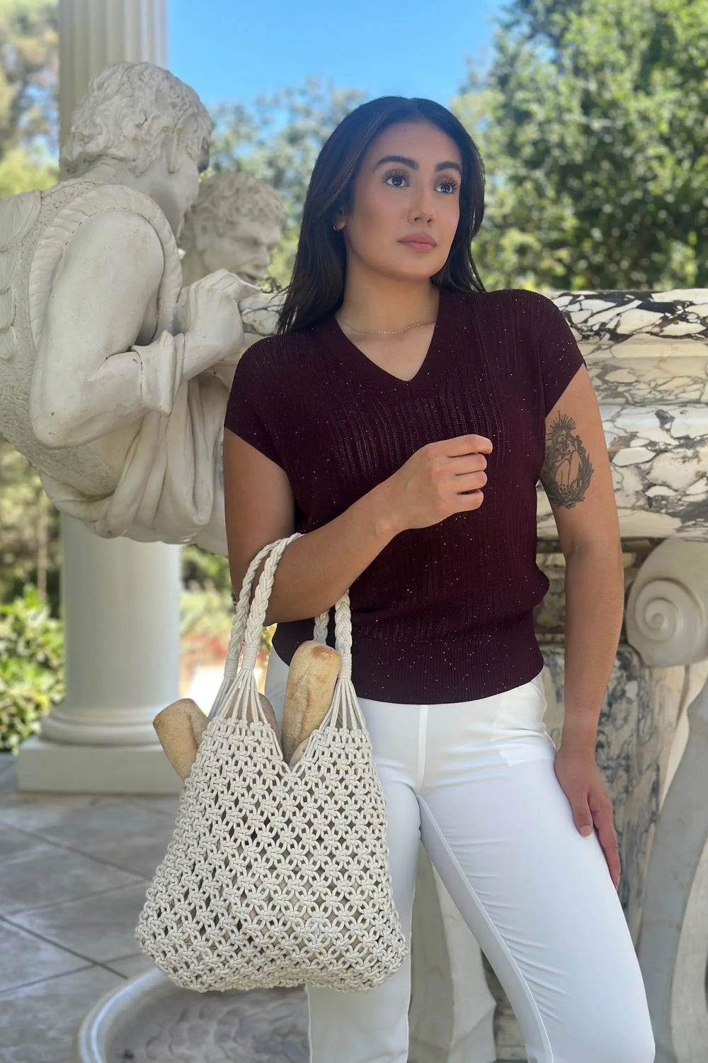 Women’s merlot sparkle ribbed knit V-neck top styled with white jeans and a handbag, upper-body front view