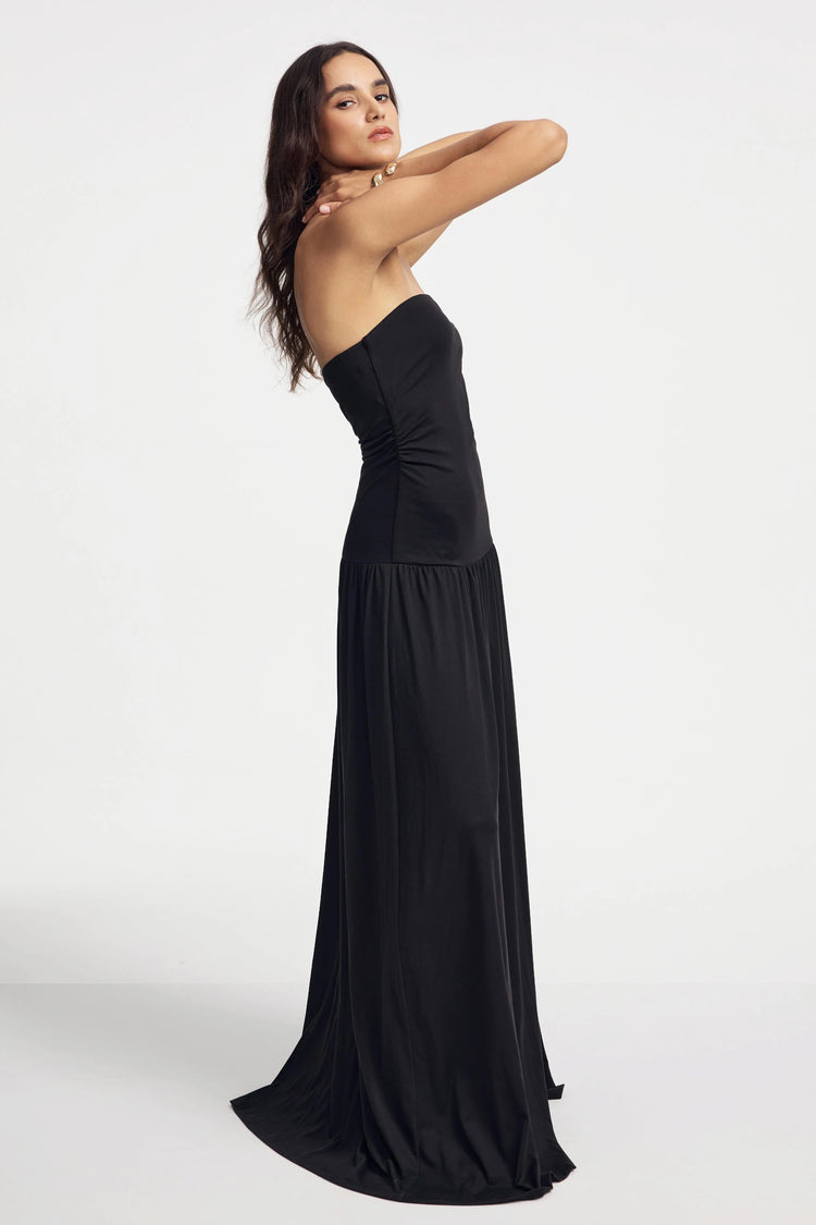 Side view of women’s black strapless maxi dress showing flowing silhouette