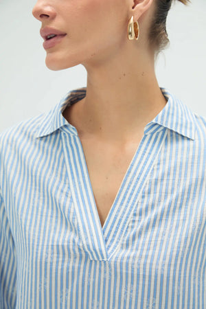Close-up of striped popover blouse neckline featuring subtle lace trim and clean finish